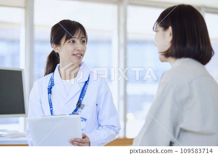 A female doctor examining a female patient in a hospital examination room 109583714