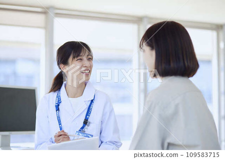 A female doctor examining a female patient in a hospital examination room 109583715
