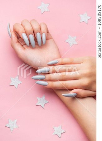 Hands with grey manicure on a pink background Hands with grey manicure on a pink background 109585170