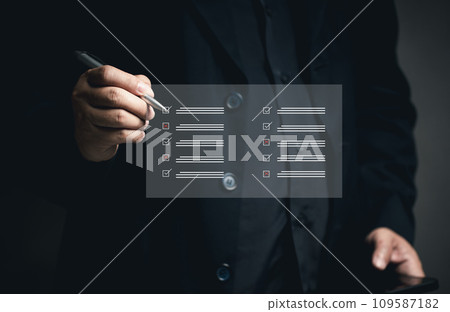 Questionnaire concept Online document management. DMS. Businessman checks list at virtual screen. Answering questionnaires about satisfaction Work via mobile phone or laptop. Satisfaction quality. 109587182