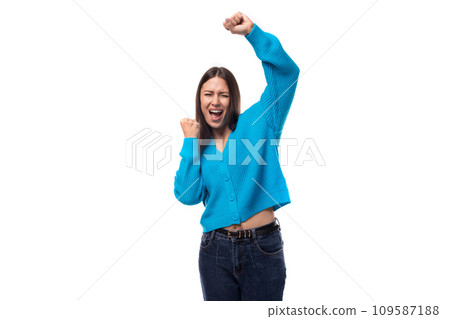 Charming caucasian woman with black hair dressed in a blue cardigan is dancing 109587188