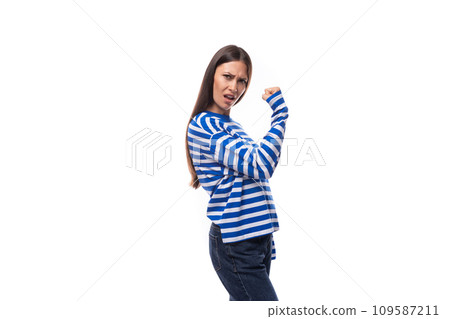 european brunette young lady wears a striped white-blue blouse and jeans on a white background 109587211