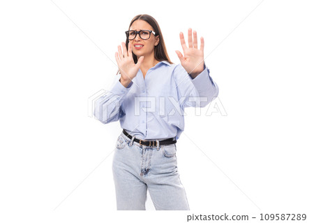 young pretty european brunette business woman with light makeup in a light blue blouse wears glasses 109587289