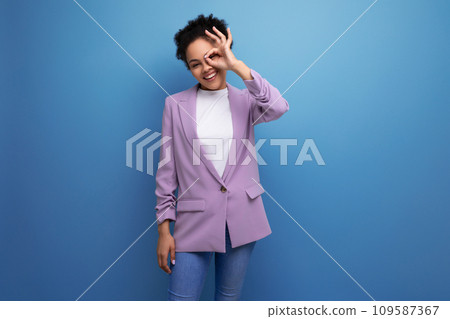 young charming successful hispanic business woman with curly hair dressed in a purple jacket on a young charming successful hispanic business woman with curly hair dressed in a purple jacket on a 109587367