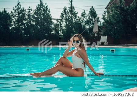 woman swimming pool. happy woman with wet hair and stylish sunglasses sunbathing in pool woman swimming pool. happy woman with wet hair and stylish sunglasses sunbathing in pool 109587368