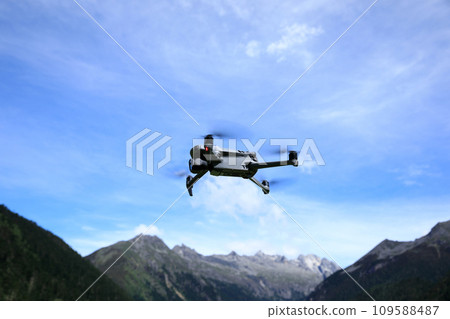 Flying drone in high altitude mountains Flying drone in high altitude mountains 109588487