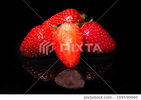 Ripe red strawberry on a black background with reflection 109590940