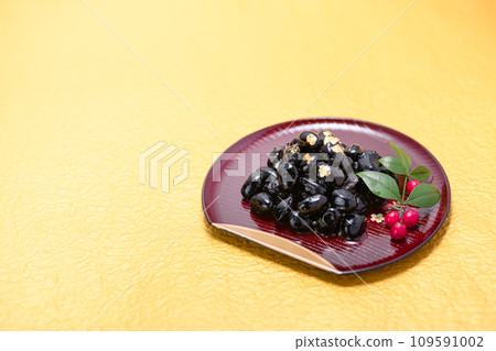 Traditional Japanese New Year dish, black beans, served with gold leaf Traditional Japanese New Year dish, black beans, served with gold leaf 109591002