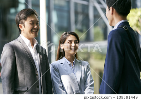 three asian business people chatting outdoors on street 109591449