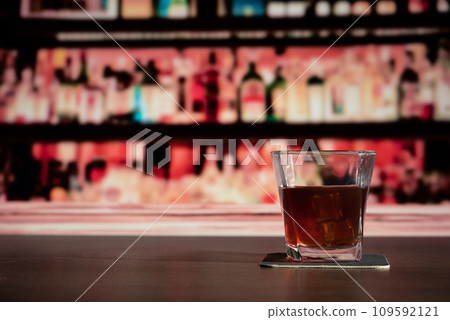 Glass of whiskey on the bar in front of the blur image bar 109592121