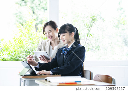 Junior high school girls and female teachers studying on tablet PCs 109592237