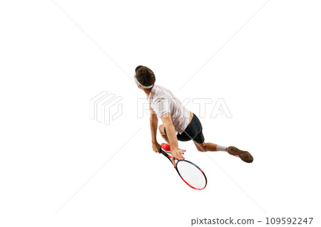 Top view. Concentrated and competitive young man in sportswear, practicing tennis game, in motion with racket, playing isolated over white background. Sport Top view. Concentrated and competitive young man in sportswear, practicing tennis game, in motion with racket, playing isolated over white background. Sport 109592247