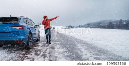 Angry man standing by electric car, battery run out of power before reaching destination. Man phone calling for help, waiting for breakdown service car, tow truck. Banner with copy space. 109593166