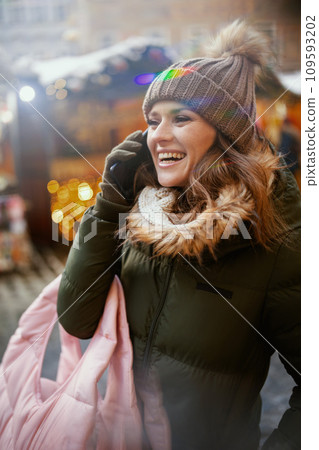 smiling female at winter fair in city talking on phone 109593202