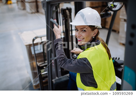 Female warehouse worker driving forklift. Warehouse worker preparing products for shipmennt, delivery, checking stock in warehouse. Female warehouse worker driving forklift. Warehouse worker preparing products for shipmennt, delivery, checking stock in warehouse. 109593269