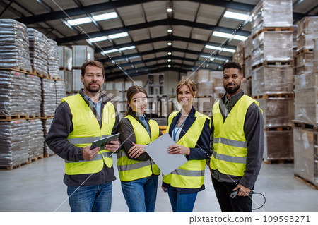 Full team of warehouse employees standing in warehouse. Team of workers in reflective clothing in modern industrial factory, heavy industry, manufactrury. Full team of warehouse employees standing in warehouse. Team of workers in reflective clothing in modern industrial factory, heavy industry, manufactrury. 109593271