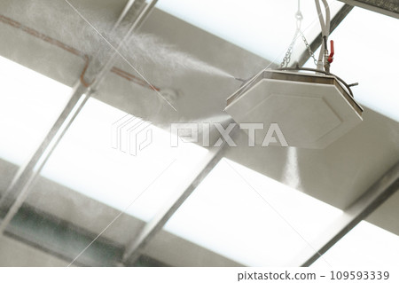 Industrial dust control system in modern manufacturing factory. Dust suppression with water mist, creating fine water mist, moistening dust particles. 109593339