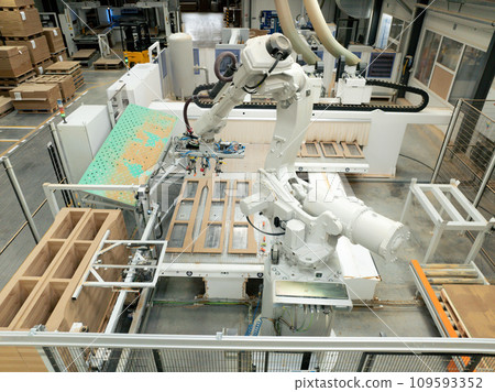 Industrial automation and robotics in modern industrial factory. High precision robotic arm assembling wooden furniture in big furniture manufacturing facility with industrial robotic manipulators. 109593352