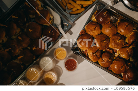 Plate with hamburgers for party, with sides and sauces. Serving hamburgers, fastfood at wedding. 109593576