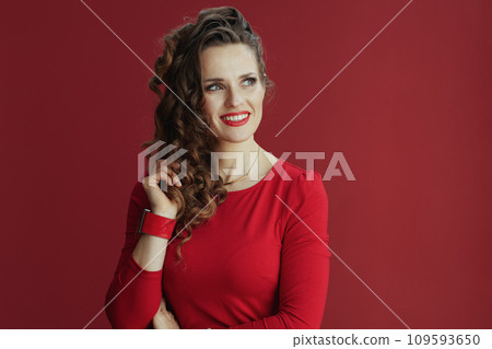 stylish woman in red dress and beret against red background 109593650
