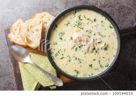 Homemade sour chicken soup with sour cream and vegetables closeup in a bowl. Horizontal top view 109594010