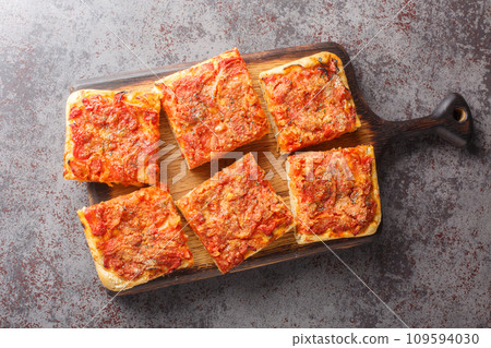 Sicilian sfincione italian pizza focaccia bread preppared with onions, tomato sauce, anchovies, caciocavallo cheese and bread crumbs closeup. Horizontal top view 109594030
