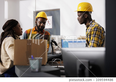 African american delivery service workers team discussing merchandise dispatching management at counter desk. All black men and woman warehouse employees register customer order parcel at reception African american delivery service workers team discussing merchandise dispatching management at counter desk. All black men and woman warehouse employees register customer order parcel at reception 109594486