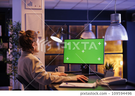 Businesswoman looking at green screen chroma key mock up computer with isolated display, working overtime at company strategy in startup office. Executive manager analyzing financial report growth 109594496