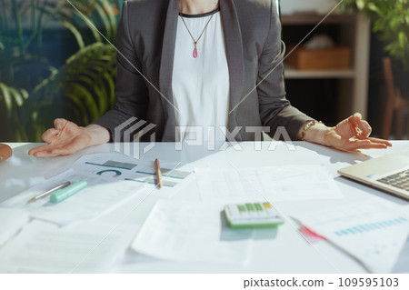 Closeup on modern business woman at work meditating 109595103