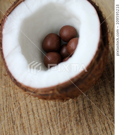 Half Of Coconut With Smooth Chocolate Candies With Nuts Inside Closeup Stock Photo 109595218