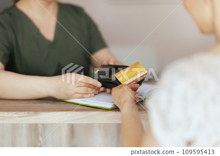 Female massage therapist in massage cabinet accepting payment 109595413