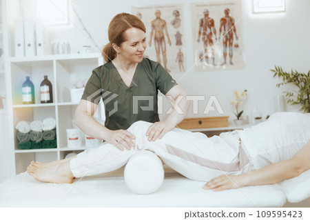 female therapist in massage cabinet conducting examination 109595423