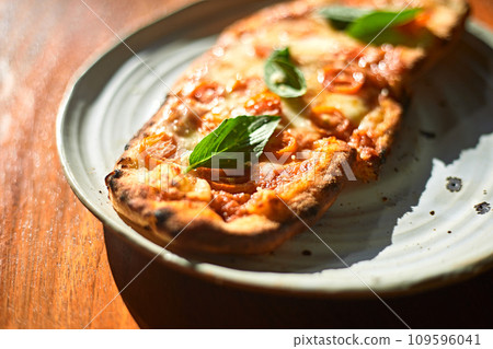 Sliced and served Italian pizza Margherita with basil leaves 109596041