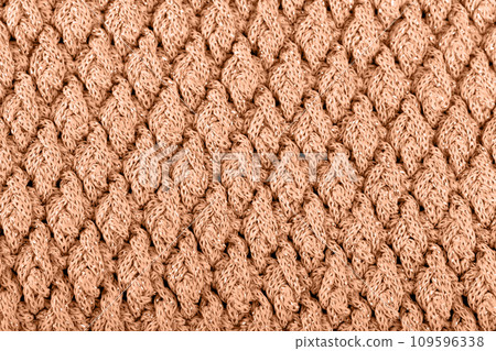 Texture of knitted woolen fabric for wallpaper toned with peach fuzz color of the year 2024 109596338