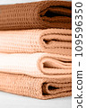 Stack of colorful cotton kitchen towels toned with color of the year 2024 Peach Fuzz 109596350
