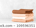 Stack of colorful cotton kitchen towels toned with color of the year 2024 Peach Fuzz 109596351