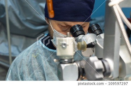 A veterinary ophthalmologist operates on a pet's eyes using a microscope. Eye microsurgery on a pet in a veterinary clinic. A surgeon operates on a pet's eye using an ophthalmic microscope. A veterinary ophthalmologist operates on a pet's eyes using a microscope. Eye microsurgery on a pet in a veterinary clinic. A surgeon operates on a pet's eye using an ophthalmic microscope. 109597297