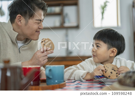 Parent and child eating cookies snack time image Parent and child eating cookies snack time image 109598248