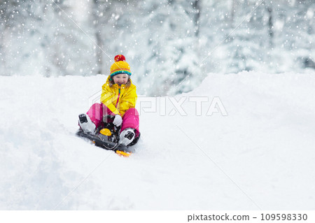 Girl on sled ride. Child sledding. Kid on sledge 109598330