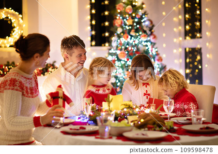 Family with kids having Christmas dinner at tree Family with kids having Christmas dinner at tree 109598478