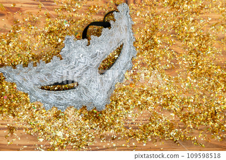 silver Venetian mask on a golden shiny background. New Year's masquerade 109598518