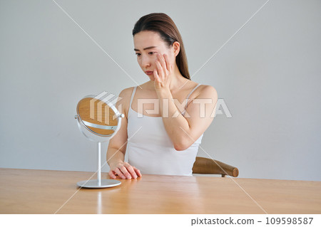 30多歲的女性在照鏡子時擔心自己皮膚上有皺紋 30多歲的女性在照鏡子時擔心自己皮膚上有皺紋 109598587