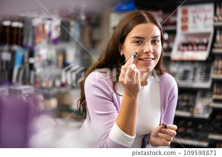 Young girl testing face concealer in beauty store Young girl testing face concealer in beauty store 109598871