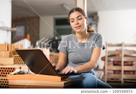 Girl using laptop to find interior design during house renovation Girl using laptop to find interior design during house renovation 109598955