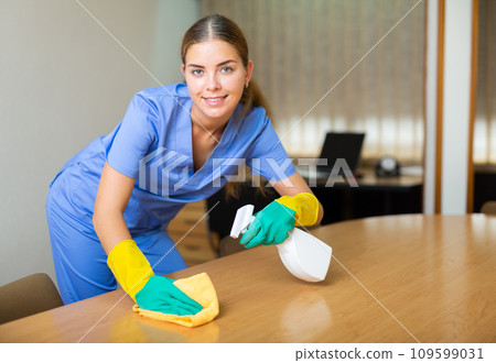 Woman wiping dust from desk 109599031