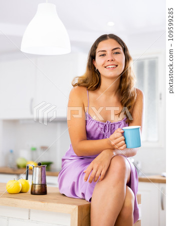 Portrait of sexy girl with cup of coffee on kitchen table at home Portrait of sexy girl with cup of coffee on kitchen table at home 109599285