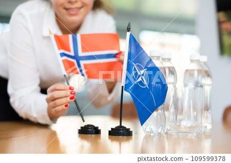 Young female secretary preparing room for international negotiations between nato and norway 109599378