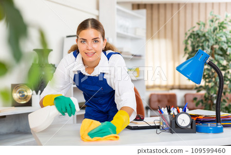 Young workwoman of cleaning service wiping furniture in office Young workwoman of cleaning service wiping furniture in office 109599460