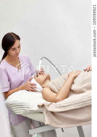 cosmetologist making procedure microdermabrasion on the face in beauty salon 109599921