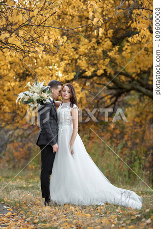 beautiful sensual bride in white wedding dress and groom standing outdoor on natural background 109600008